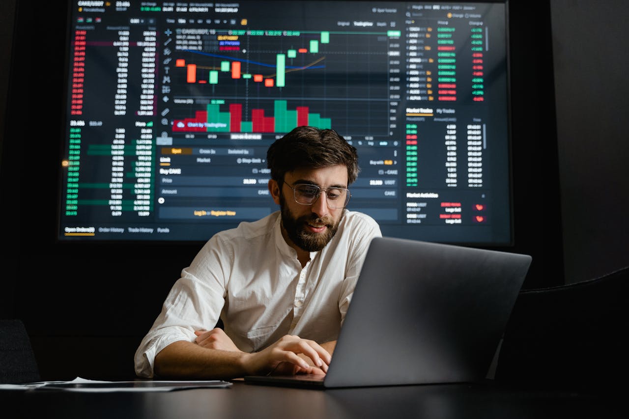 about-01 Male analyst studies cryptocurrency trends at a workstation with multiple displays showing market data.